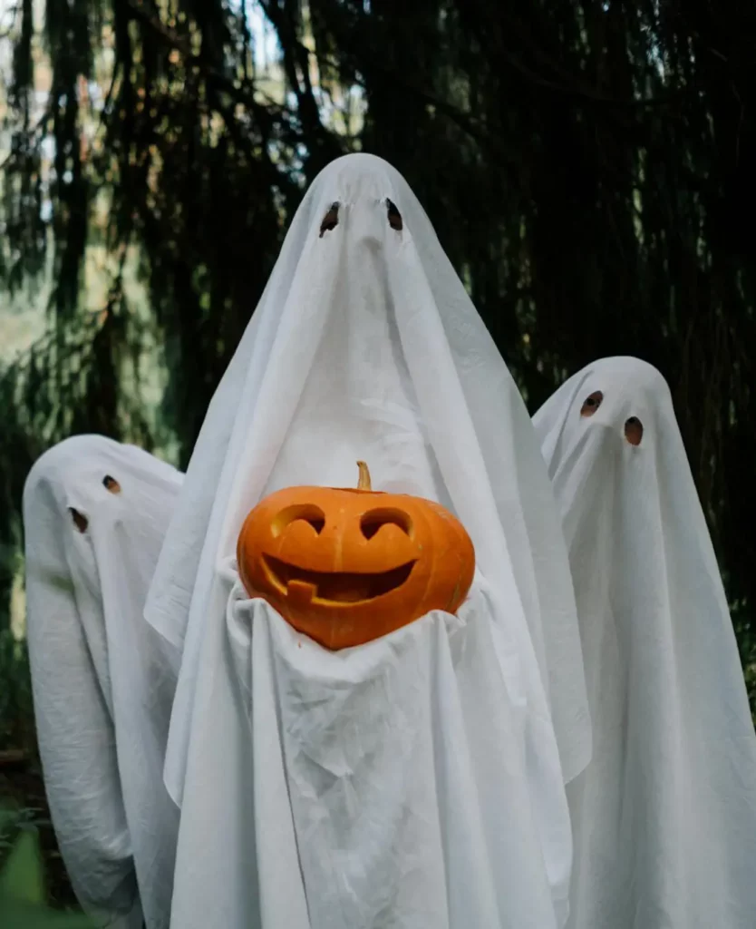 3 enfants déguisés en fantômes pour Halloween