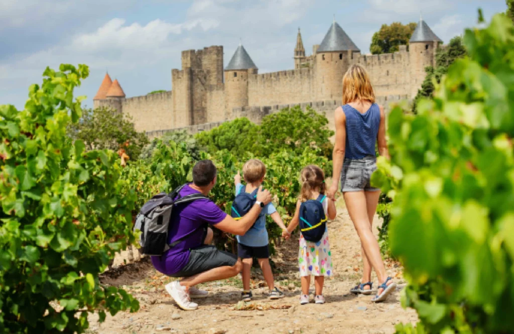 Famille devant la cité de Carcassonne lors de leurs vacances durables
