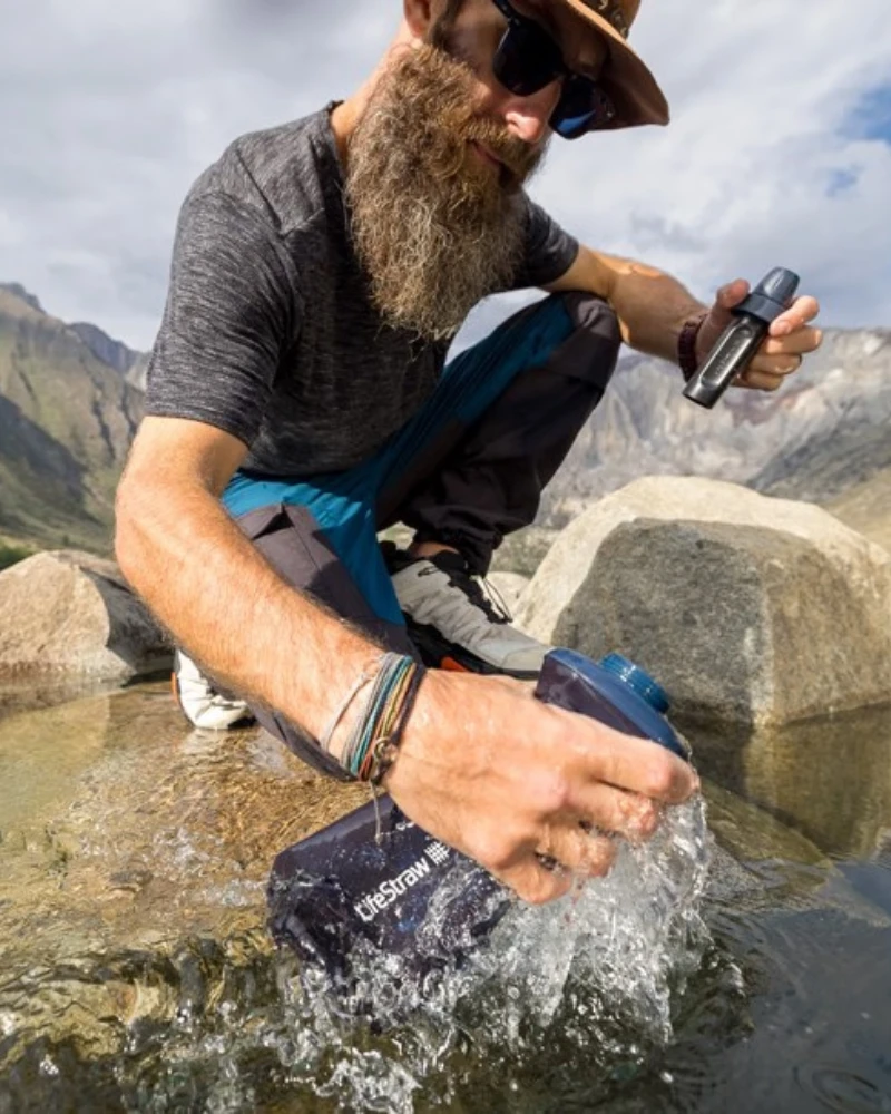 Homme remplissant sa gourde filtrante Lifestraw dans une rivière