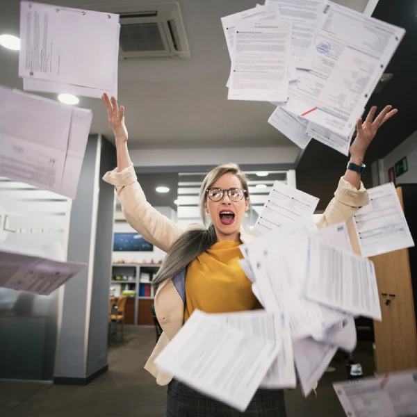 Femme au bureau qui lance des papiers en l'air