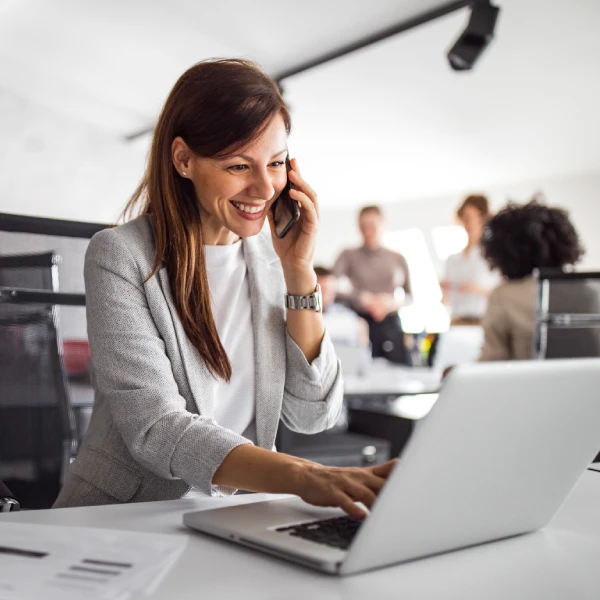 Femme au travail qui sourit au téléphone