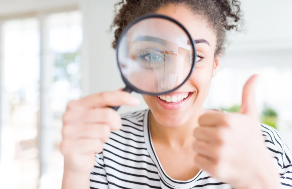 Femme souriante regardant dans une loupe