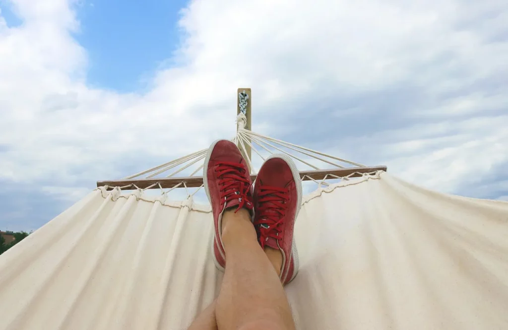 Homme dans un hamac se reposant les jambes croisées